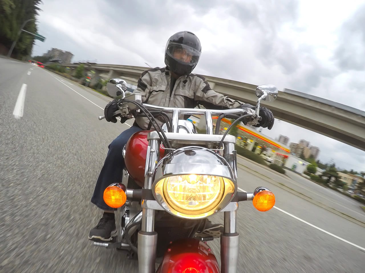 man riding motorcycle and taking a turn on a busy highway