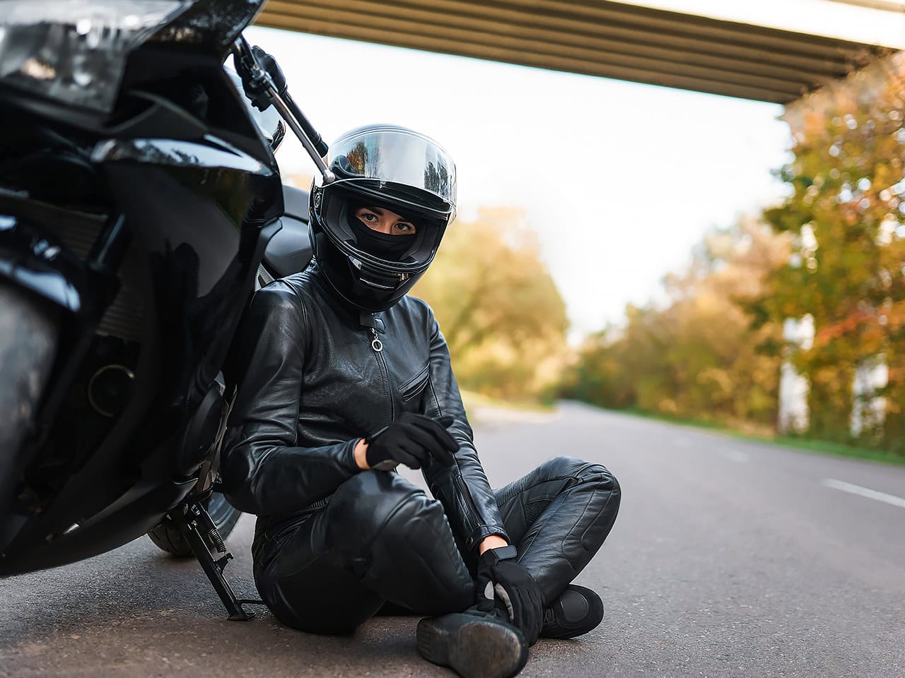Motorcyclist sitting next to her bike